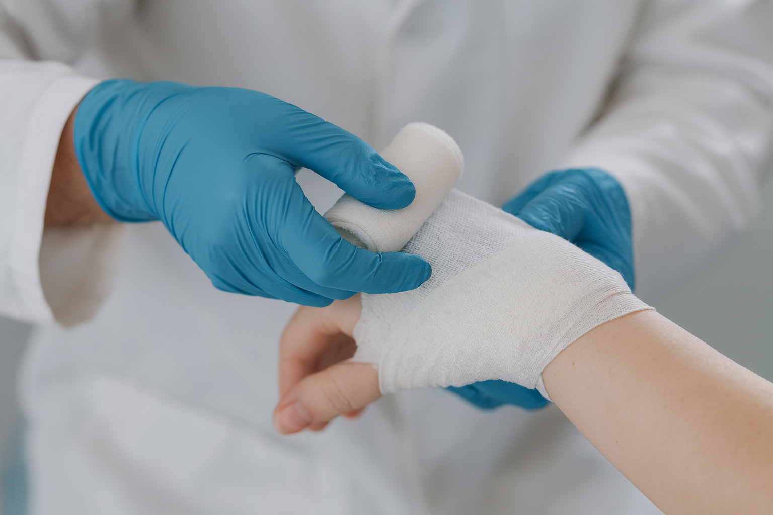 Medical professional wrapping a patient's wrist with a bandage